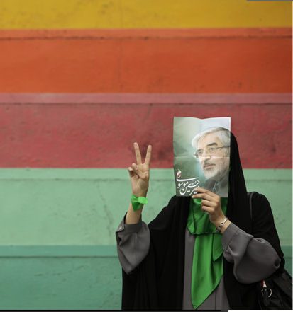 Moussavi supporter masks her face with candidate's image (Ben Curtis-AP)